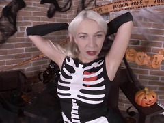 Blonde girl in skeleton costume fingers pussy after reveals tits