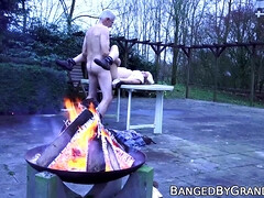 Cute babe rides old mans dick cowgirl style by the campfire