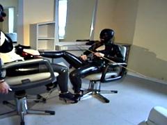 Tied to the barber chair, she is fingered hard in her latex suit