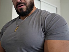 Muscular handsome guy flexes his chest in a tight shirt